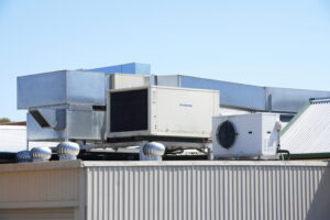 Commercial HVAC equipment and fans on top of roof.