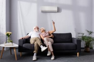 couple-sitting-on-couch-in-front-of-a-ductless-mini-split-air-handler
